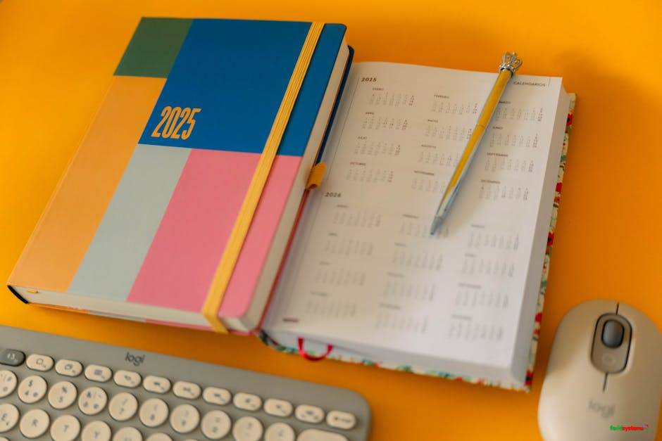Colorful 2025 planner and calendar with pen on a bright yellow desk.