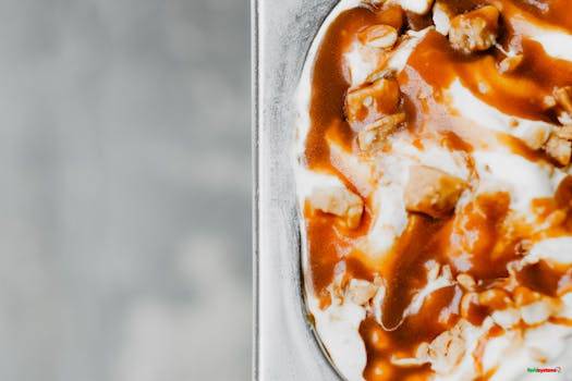 Close-up of creamy ice cream topped with rich caramel sauce and nuts, perfect for dessert lovers.